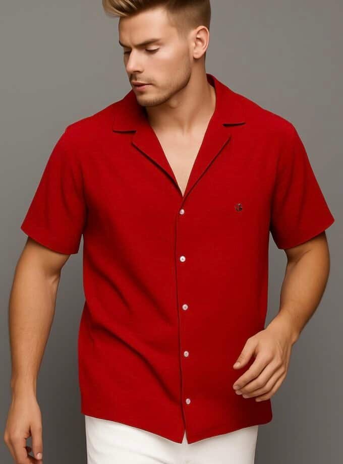 Red short-sleeve button-up shirt for men, casual summer fashion, styled with white pants, modern men's apparel, lightweight and comfortable clothing, suitable for warm weather and stylish occasions.
