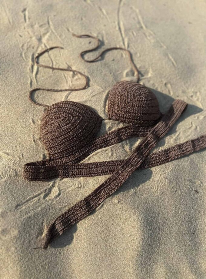 Colorful crochet bikini top on sandy beach, perfect for summer beachwear and swimwear fashion.