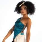 Luxury fashion model wearing stylish satin top and printed pants, accessorized with scrunchie and gold jewelry, fashion photography, trendy clothing, elegant style, contemporary runway look.