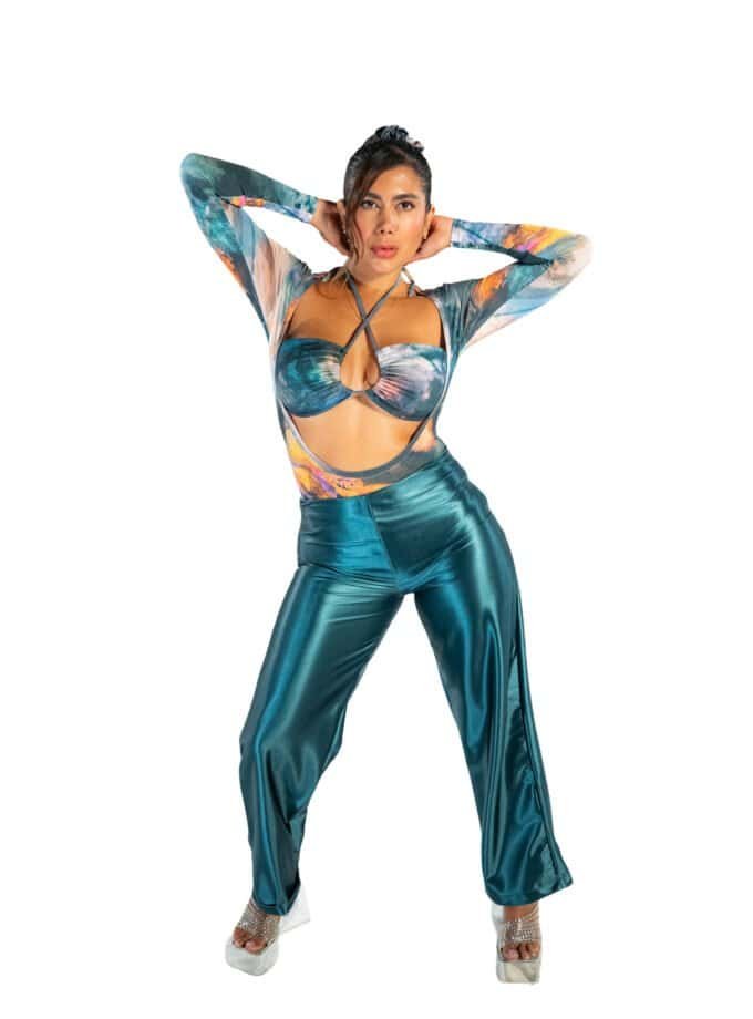 Vibrant colorful fashion model wearing metallic teal pants and a matching cut-out top with a watercolor print, styled in bold, trendy 2023 fashion for a chic and modern look.