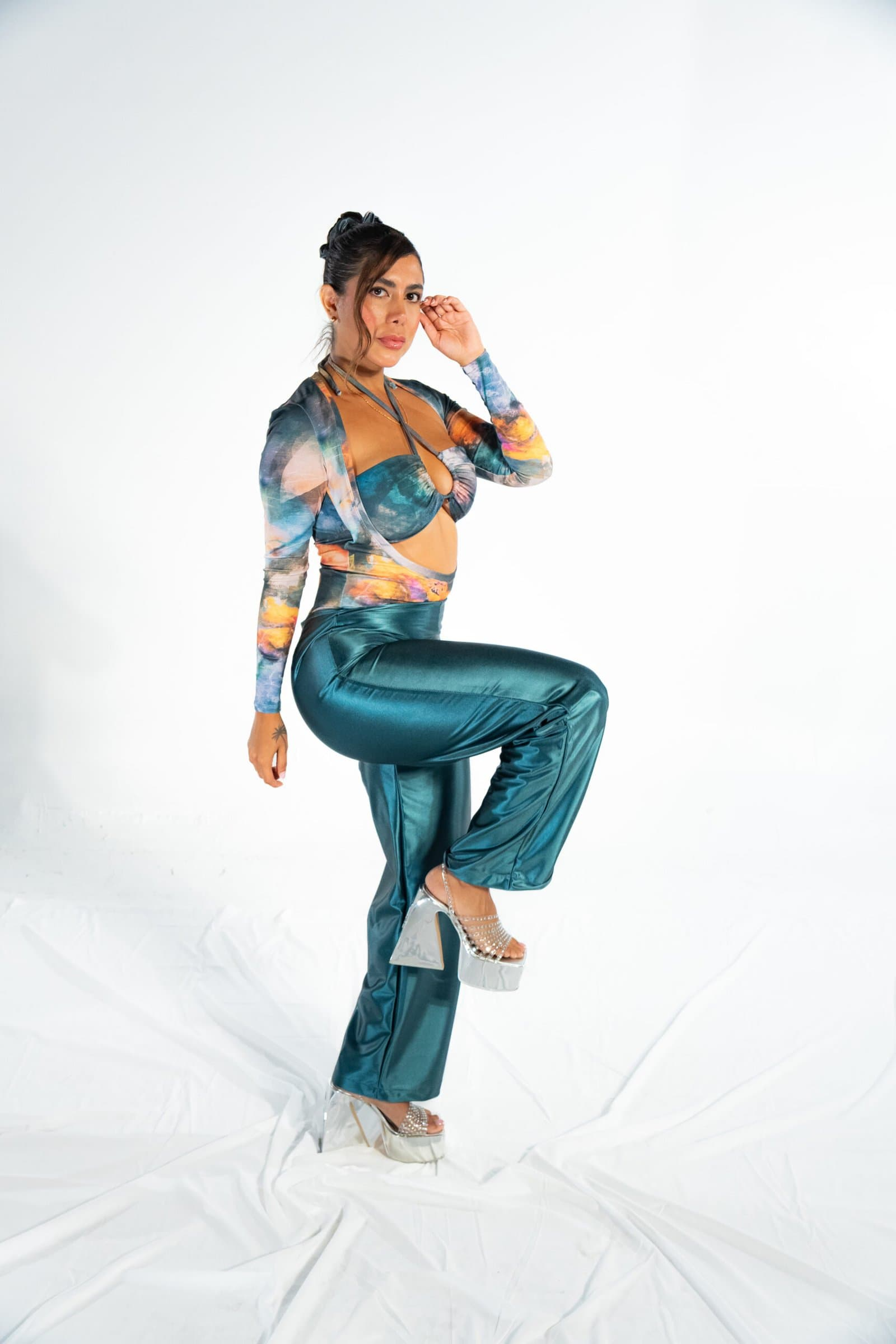 Vegan leather pants and colorful patterned top with cut-out design styled for a modern fashion photoshoot.