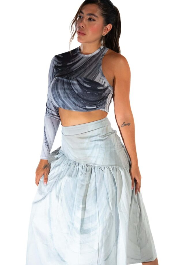 Vegan woman wearing a stylish, abstract black and white crop top paired with a flowing white maxi skirt, emphasizing modern fashion, fitness, and sustainable clothing.