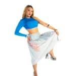 Vibrant woman in bold blue crop top, flowing floral skirt, and silver platform heels posing confidently for fashion shoot.
