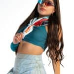 Bright woman in sporty outfit wearing stylish sunglasses and colorful scarf, promoting confiture New York boutique, fashion accessories, and chic casual style.