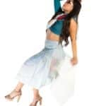 Vibrant fashion-forward woman wearing a colorful crop top, flowing skirt, and high heels against a white background, showcasing stylish summer or casual look.