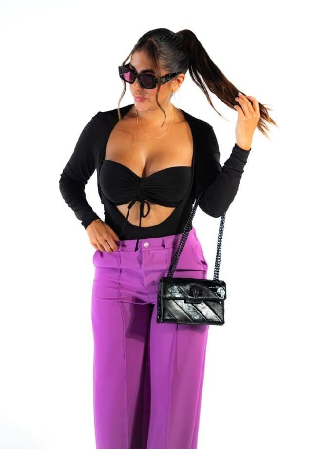 Luxury fashionable woman in black and purple outfit, oversized sunglasses, carrying black handbag, stylish, contemporary fashion, confident pose, trendy accessories, isolated on white background.