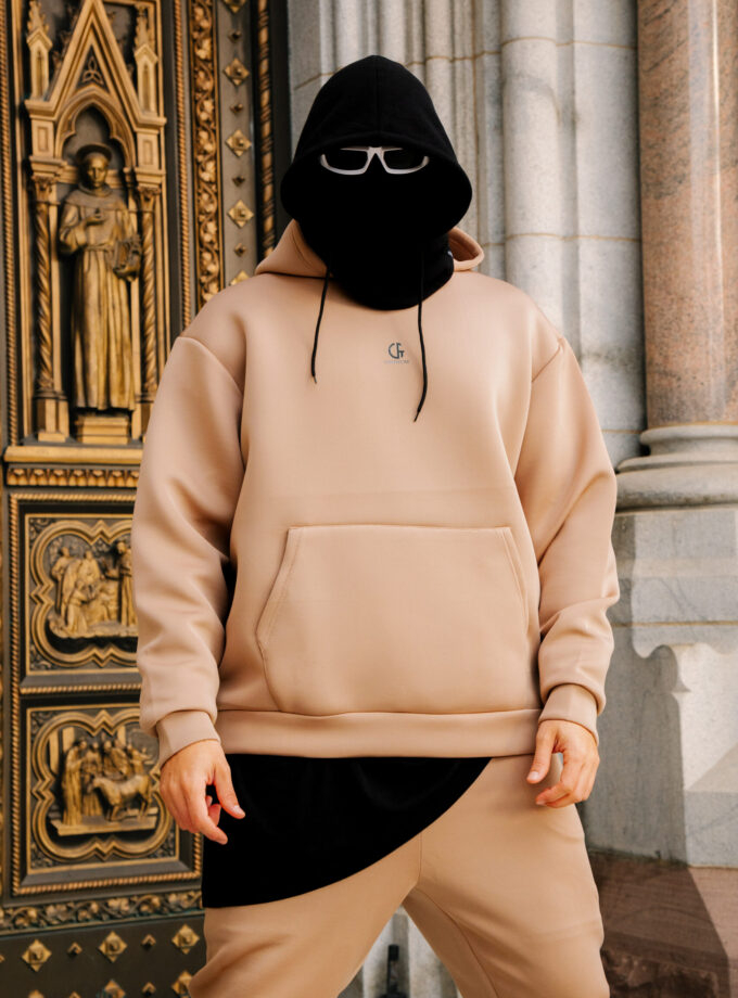 Comfy beige hoodie with a minimalist logo, paired with matching joggers, casual streetwear fashion for men and women, stylish and comfortable for everyday wear.