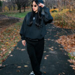 Muted black hoodie, stylish sunglasses, and casual black joggers in an autumn park setting, showcasing cozy and trendy fall fashion. Perfect for outdoor casual wear and fall street style.