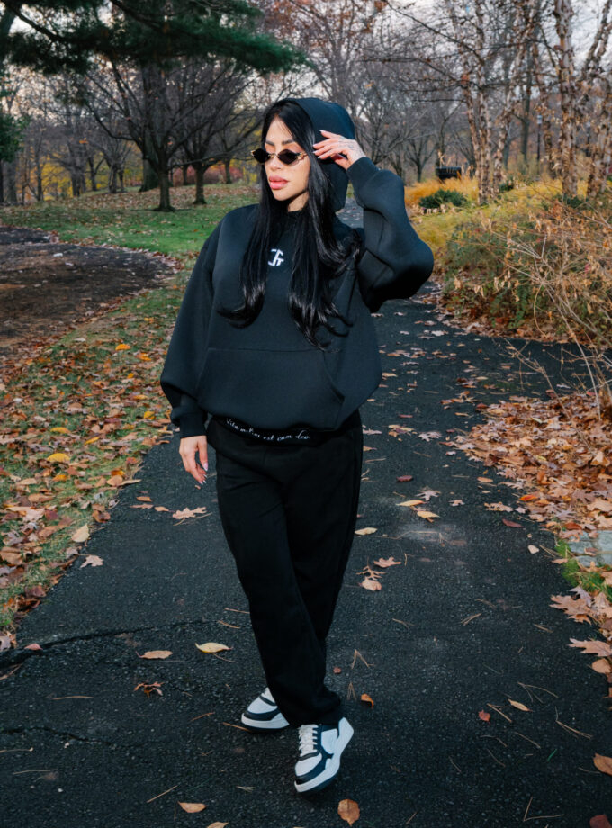 Muted black hoodie, stylish sunglasses, and casual black joggers in an autumn park setting, showcasing cozy and trendy fall fashion. Perfect for outdoor casual wear and fall street style.