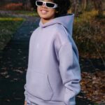 Comfortable young man wearing lilac hoodie and joggers enjoying fall outdoor walk, showcasing cozy athleisure fashion perfect for outdoor activities, autumn style, and casual wear.